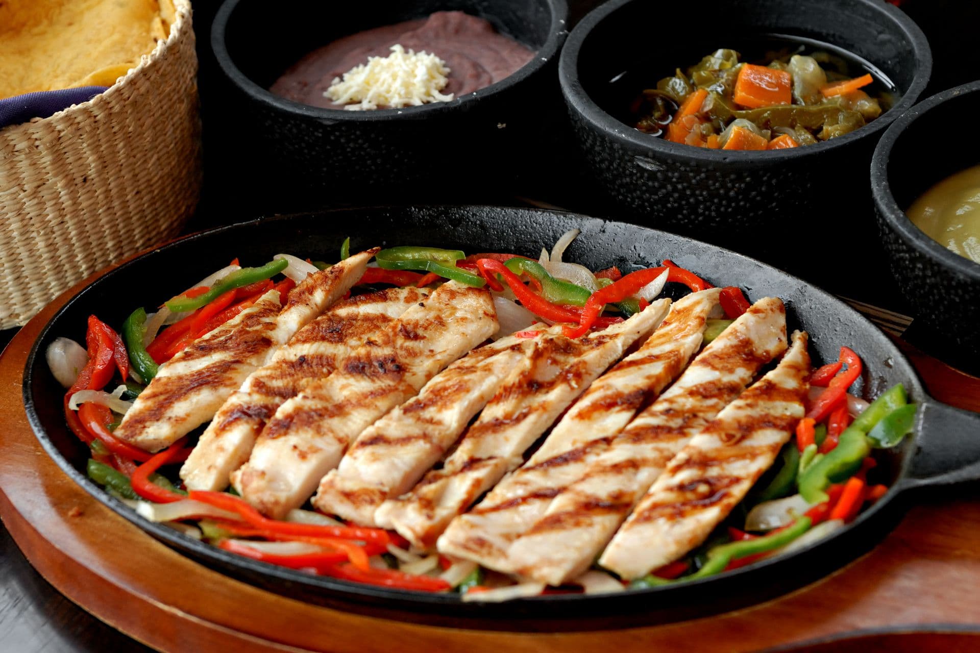 Grilled chicken fajita strips with red and green peppers in a cast-iron skillet