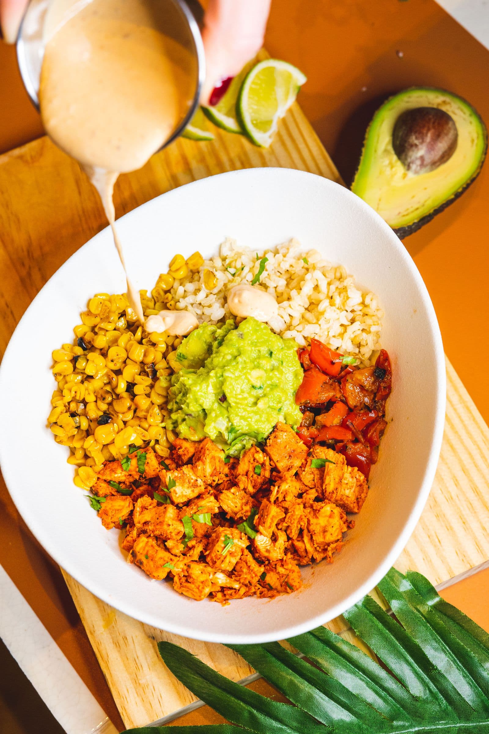 Chicken fajita bowl with charred corn, guacamole, peppers and rice