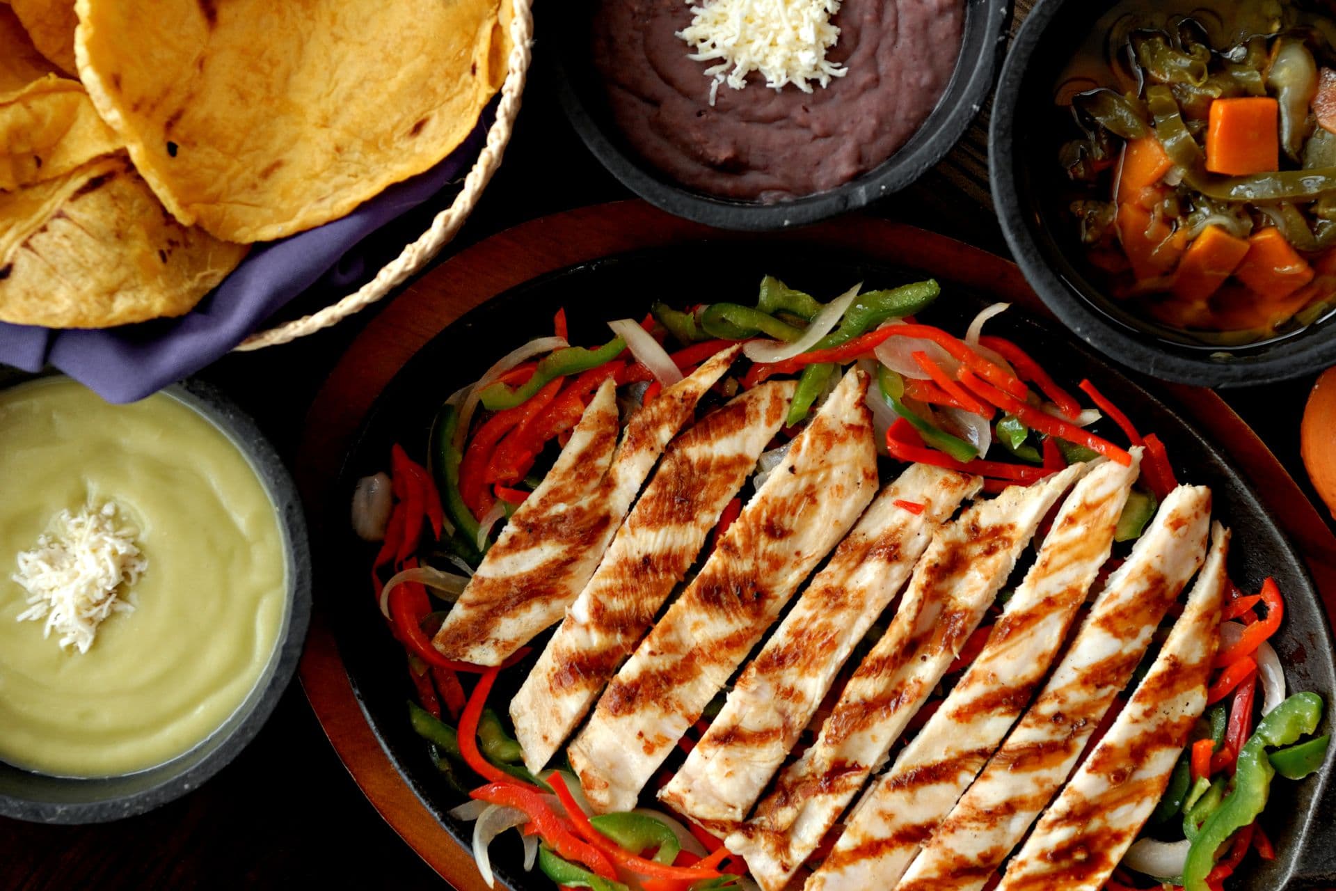 Grilled chicken fajita strips with colorful peppers and traditional sides