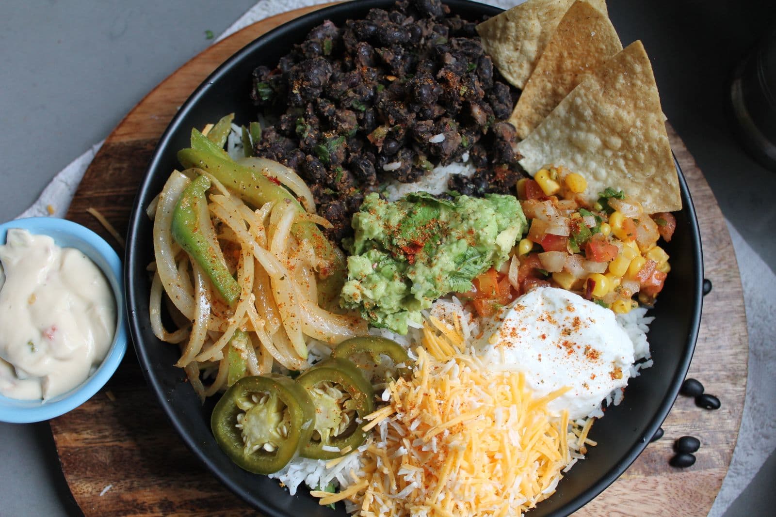 Veggie fajita bowl with black beans, peppers, guacamole and cheese