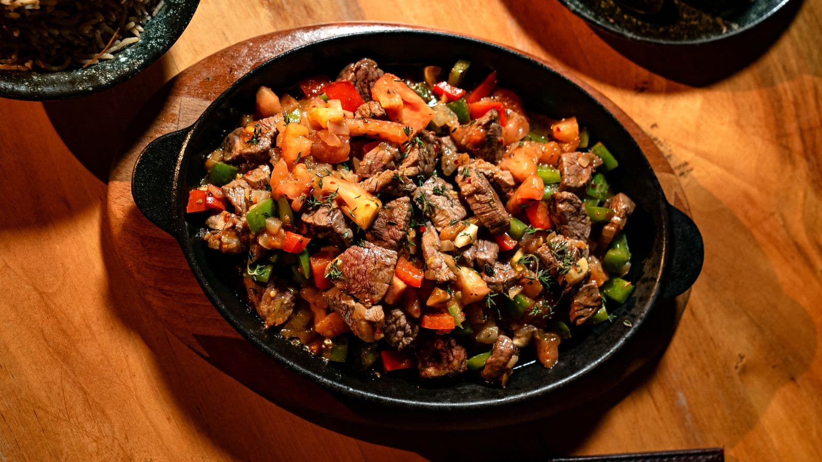 Sizzling steak and peppers in a cast-iron skillet