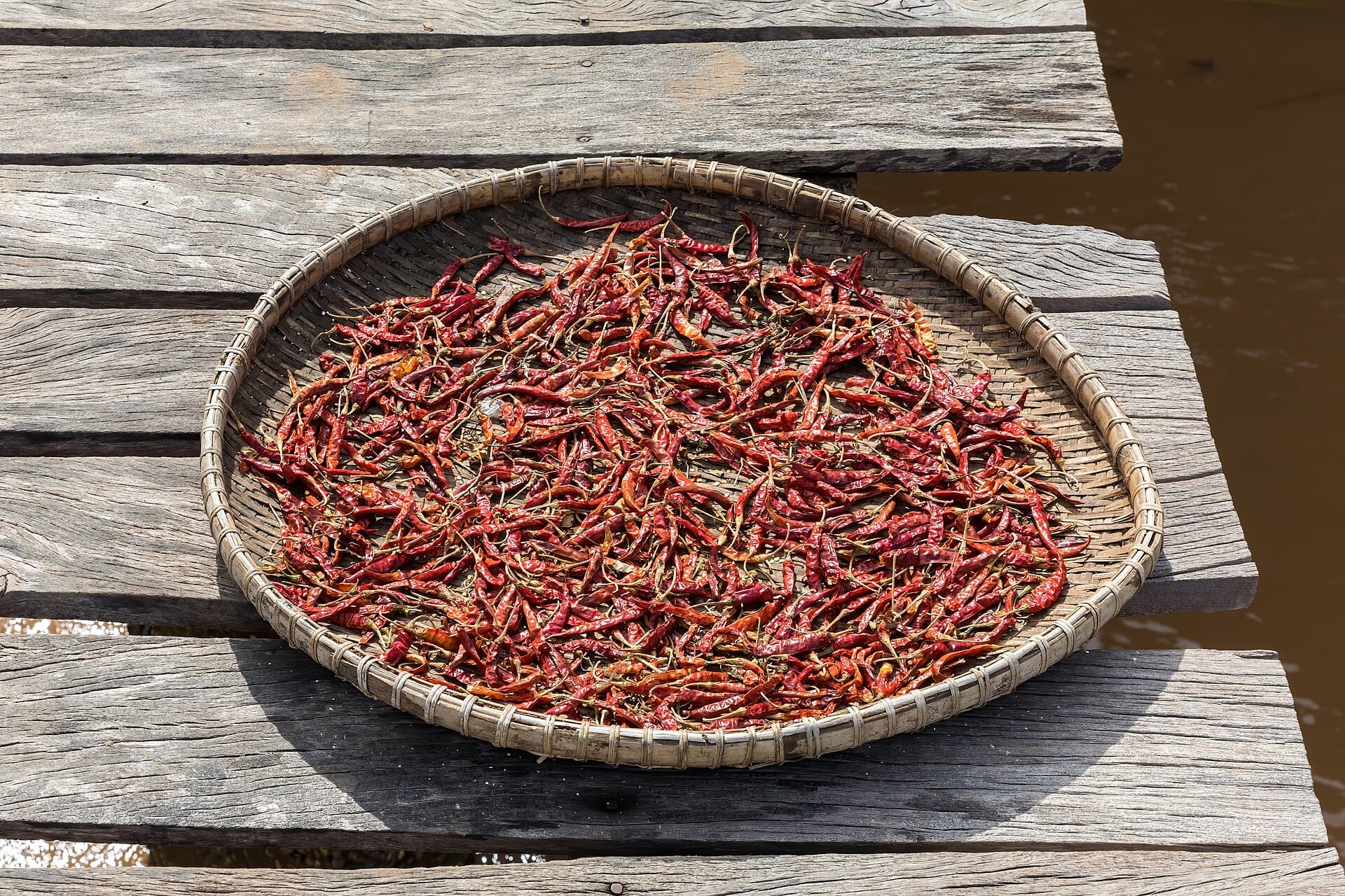 Red chili peppers drying on a footbridge